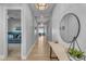 Bright hallway with wood floors, elegant lighting, and a stylish round mirror on a console table at 10144 E Thistle Ave, Mesa, AZ 85212