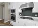 Close-up of modern stainless steel microwave, gas range, and hood over quartz counters at 10144 E Thistle Ave, Mesa, AZ 85212