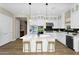 Open kitchen with a center island, wooden stools, white cabinets, and stainless steel appliances at 10144 E Thistle Ave, Mesa, AZ 85212