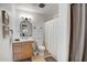 Bright bathroom with white finishes, a wooden vanity, and a shower with a curtain at 1015 E Concorda Dr, Tempe, AZ 85282