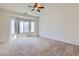 Bedroom features large bay windows, neutral carpet, ceiling fan, and ample natural light at 11725 W Jefferson St, Avondale, AZ 85323