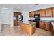 Functional kitchen features granite counters, a center island, and wood cabinetry at 11725 W Jefferson St, Avondale, AZ 85323