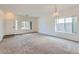 Bright, open living room with neutral carpeting and ample natural light from large windows at 11725 W Jefferson St, Avondale, AZ 85323