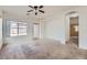 Bright living room with carpet, ceiling fan, white walls, and access to the backyard at 11725 W Jefferson St, Avondale, AZ 85323