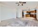 Spacious living room with neutral carpet and a ceiling fan, adjacent to the kitchen at 11725 W Jefferson St, Avondale, AZ 85323