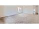 Spacious living room featuring neutral carpet, white walls, and bright natural lighting at 11725 W Jefferson St, Avondale, AZ 85323