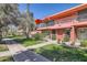 Charming two-story pink condo building with landscaped front yard and red umbrellas on the balcony at 126 E Coronado Rd # 39, Phoenix, AZ 85004