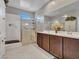 Modern bathroom featuring a glass shower, double vanity with dark cabinets, and neutral wall paint at 13451 W Remuda Dr, Peoria, AZ 85383