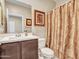 Bathroom features a single sink vanity and toilet with a decorative shower curtain at 13451 W Remuda Dr, Peoria, AZ 85383