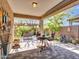 Inviting covered patio with wrought iron furniture, a paver patio and views of the landscaped backyard at 13451 W Remuda Dr, Peoria, AZ 85383