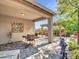 Inviting covered patio with wrought iron furniture, a paver patio and views of the landscaped backyard at 13451 W Remuda Dr, Peoria, AZ 85383