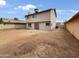 Expansive backyard featuring a large, empty lot, and a two-story house with red-trimmed sliding glass doors at 1810 W Kiowa Cir, Mesa, AZ 85202