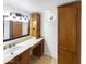 Bathroom vanity with granite counters, wood cabinets, undermount sink, and decorative lighting at 1810 W Kiowa Cir, Mesa, AZ 85202