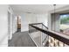 Upstairs hallway with iron and wood banister and a window for natural light at 1810 W Kiowa Cir, Mesa, AZ 85202