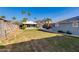 Wide backyard featuring well-maintained lawn, block fencing, and lush palm trees under a clear blue sky at 1822 N Laurel Ave, Phoenix, AZ 85007