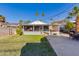 Cozy home with covered porch, complemented by a well-kept lawn and mature palm trees, creating a welcoming atmosphere at 1822 N Laurel Ave, Phoenix, AZ 85007