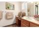 Bathroom featuring a mirror, floral decor, towels, and vanity with sink and wooden cabinets at 1859 E Gemini Dr, Tempe, AZ 85283