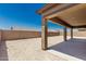 View of the home's backyard with a covered patio and desert landscaping at 20261 W Monterey Way, Buckeye, AZ 85396