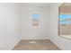 Bright bedroom featuring a window, neutral tile floors, and white walls at 20261 W Monterey Way, Buckeye, AZ 85396