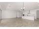 Open concept with tile flooring that connects living, dining, and kitchen areas, and modern chandelier at 20261 W Monterey Way, Buckeye, AZ 85396