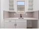 Stylish bar area with white cabinets, quartz countertops, tile backsplash, and modern fixtures at 20273 W Monterey Way, Buckeye, AZ 85396