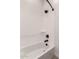 Pristine bathtub and shower with black fixtures, offering a modern and minimalist aesthetic at 20273 W Monterey Way, Buckeye, AZ 85396