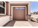 Exterior view of a stylish brown garage door complementing the home's facade and landscaping at 20273 W Monterey Way, Buckeye, AZ 85396