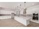 Spacious kitchen showcasing white cabinets, a quartz island, stainless steel appliances, and tile backsplash at 20273 W Monterey Way, Buckeye, AZ 85396