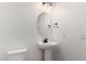 Modern powder room with a pedestal sink, oval mirror, and sleek fixtures at 20273 W Monterey Way, Buckeye, AZ 85396