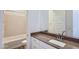 Bathroom featuring a bathtub, tile surround, a single sink, and light-colored cabinets at 21949 E Twin Acres Dr, Queen Creek, AZ 85142