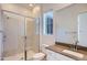 Bathroom featuring a walk-in shower with glass enclosure, a single sink, and a window at 21949 E Twin Acres Dr, Queen Creek, AZ 85142