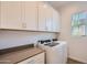 Laundry room featuring modern washer and dryer, countertop, and white cabinets at 21949 E Twin Acres Dr, Queen Creek, AZ 85142