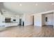 Spacious living room featuring wood-look tile flooring, white walls, and an open layout to the kitchen at 21949 E Twin Acres Dr, Queen Creek, AZ 85142