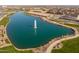 Panoramic aerial view of a lake with a fountain, surrounded by lush green spaces and community walkways at 23102 E Raven Dr, Queen Creek, AZ 85142