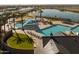 Aerial view of a resort-style pool and splash pad with multiple amenities and a calming lake view at 23102 E Raven Dr, Queen Creek, AZ 85142