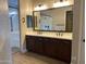 Elegant bathroom with double vanity, dark wood cabinets, a large mirror, and a glass-enclosed shower at 23102 E Raven Dr, Queen Creek, AZ 85142