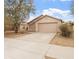 Tan single story home featuring a two car garage, desert landscaping, and a concrete driveway at 2323 W Carson Rd, Phoenix, AZ 85041