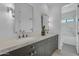 Bathroom with dual vanities, sleek dark cabinets, stylish mirrors, and modern light fixtures at 24417 N 87Th St, Scottsdale, AZ 85255