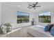 Sunlit bedroom featuring a comfortable chair, a modern bed, and large windows at 24417 N 87Th St, Scottsdale, AZ 85255