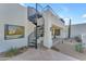 Exterior of a house with a spiral staircase leading to a balcony and desert landscaping at 24417 N 87Th St, Scottsdale, AZ 85255