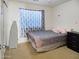 Simple bedroom with a patterned comforter, window, and ironing board at 25879 W Elizabeth Ave, Buckeye, AZ 85326