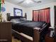 Bedroom with a dark-colored bed, Dodgers memorabilia, and dark curtains at 25879 W Elizabeth Ave, Buckeye, AZ 85326