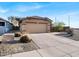 Tan single story home with a two car garage, desert landscaping, and concrete driveway at 25879 W Elizabeth Ave, Buckeye, AZ 85326