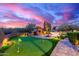 Backyard putting green with patio, fireplace, and desert sunset backdrop at 30600 N Pima Rd # 49, Scottsdale, AZ 85266