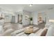 This virtually staged living room features an open floor plan with neutral paint, wood-look tile flooring, and bright light at 4634 W Aire Libre Ave, Glendale, AZ 85306