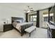 Serene main bedroom featuring a large window with outdoor access, dark wood furniture, and contemporary decor at 4777 S Fulton Ranch Blvd # 1103, Chandler, AZ 85248