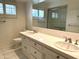 Bathroom featuring double sinks, white tile countertops, white cabinets, and a large mirror at 511 W Ocotillo Rd, Phoenix, AZ 85013