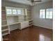 Bedroom with hardwood floors, built-in shelving, storage cabinets, and a window with natural light at 511 W Ocotillo Rd, Phoenix, AZ 85013