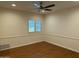 Bright bedroom featuring hardwood floors, ceiling fan, and natural light from a window with shutters at 511 W Ocotillo Rd, Phoenix, AZ 85013