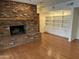 Living room with brick fireplace, built in shelving, and hardwood floors at 511 W Ocotillo Rd, Phoenix, AZ 85013